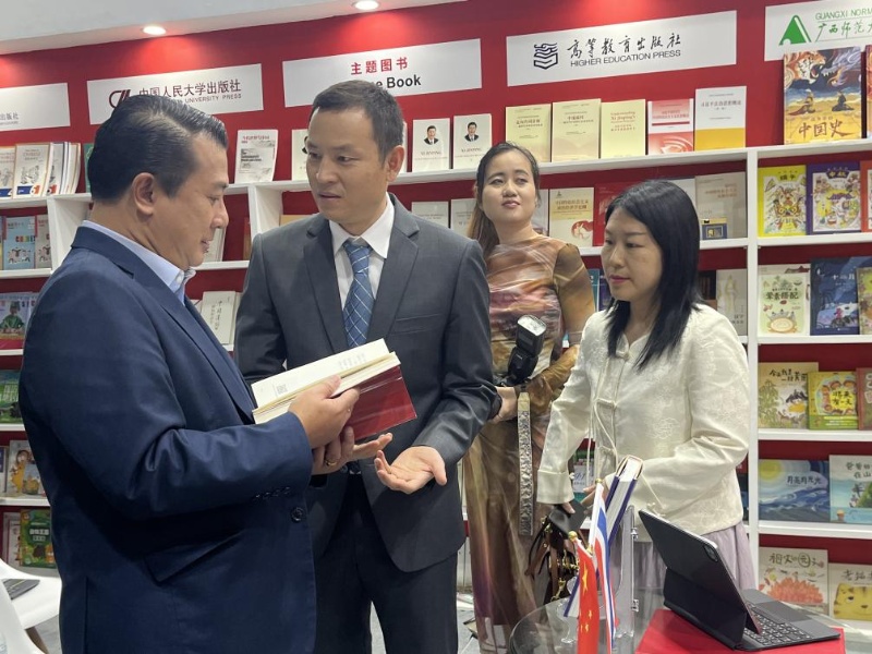 泰國書(shū)商和出版商協(xié)會(huì )主席蘇維奇（左一）在翻閱《近鏡頭：溫暖的瞬間》。（盧雯 攝）jpg_副本.jpg