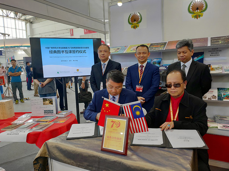 廣西師范大學(xué)出版社集團黨委書(shū)記、董事長(cháng)張藝兵（左前一）與馬來(lái)西亞國家語(yǔ)文出版局理事長(cháng)Datuk Abang Sallehuddin Abang Shokeran簽訂合約（陳子鋒攝）.jpg