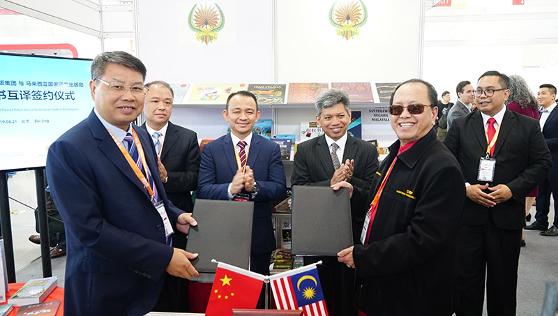 廣西師范大學(xué)出版社集團黨委書(shū)記、董事長(cháng)張藝兵（左前一）與馬來(lái)西亞國家語(yǔ)文出版局理事長(cháng)Datuk Abang Sallehuddin Abang Shokeran交換簽約文件（陳子鋒攝）.jpg