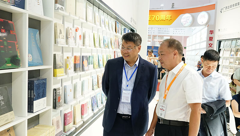 集團公司黨委書(shū)記、董事長(cháng)張藝兵向校黨委副書(shū)記趙鐵詳細介紹出版社圖書(shū)（陳子鋒攝）.JPG